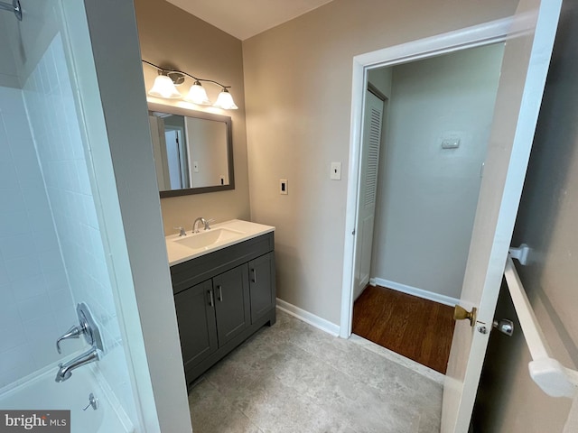 full bathroom featuring vanity, a shower, and baseboards