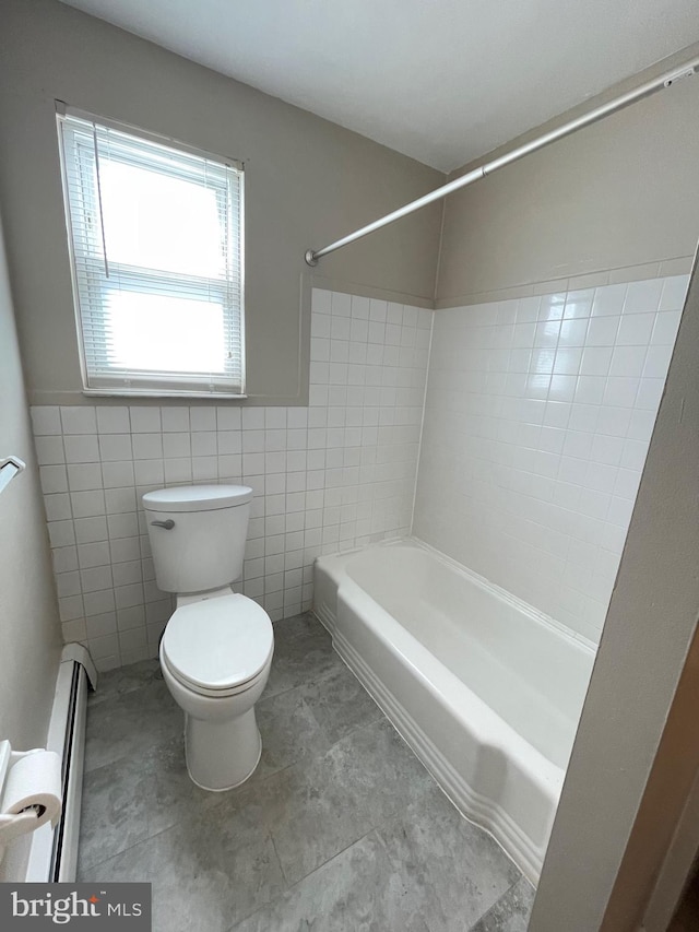 bathroom with toilet, baseboard heating, tub / shower combination, and tile walls