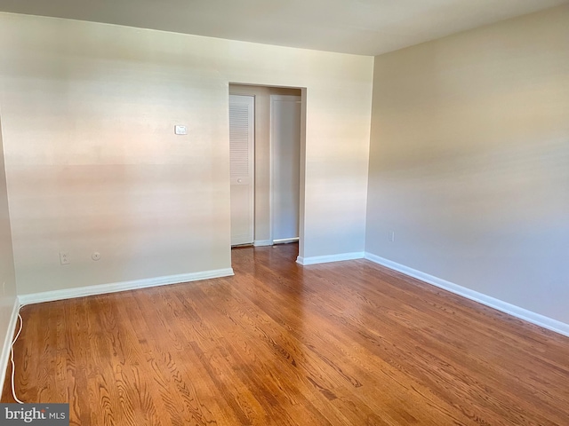 empty room featuring wood finished floors and baseboards