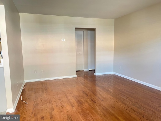 empty room with wood finished floors and baseboards