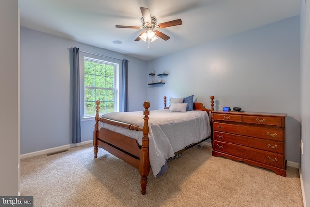 bedroom featuring light colored carpet, baseboards, and a ceiling fan