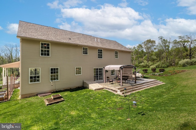 rear view of property with a wooden deck and a lawn