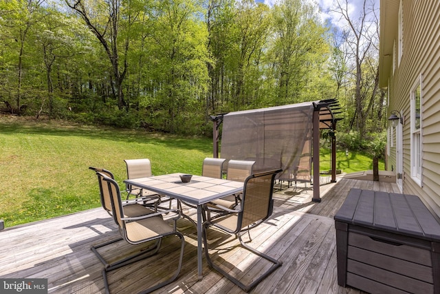 wooden deck featuring outdoor dining area and a lawn