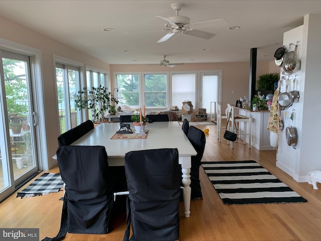dining space featuring light wood finished floors, a ceiling fan, recessed lighting, and baseboards