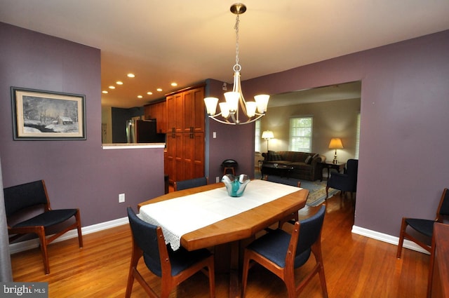 dining space featuring light wood-type flooring, a chandelier, recessed lighting, and baseboards