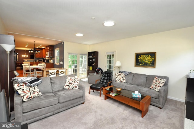 living area with a chandelier, light carpet, and recessed lighting