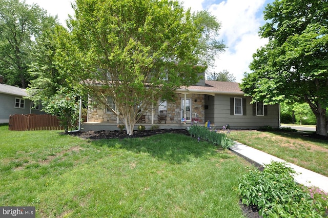 view of front facade featuring stone siding, covered porch, and a front lawn