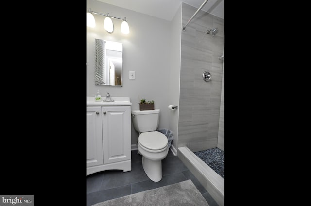 full bath featuring tile patterned floors, toilet, tiled shower, and vanity