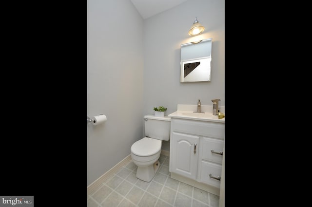 bathroom with toilet, tile patterned flooring, vanity, and baseboards