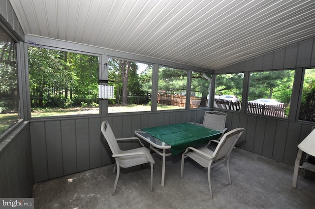 sunroom / solarium with lofted ceiling and outdoor dining area