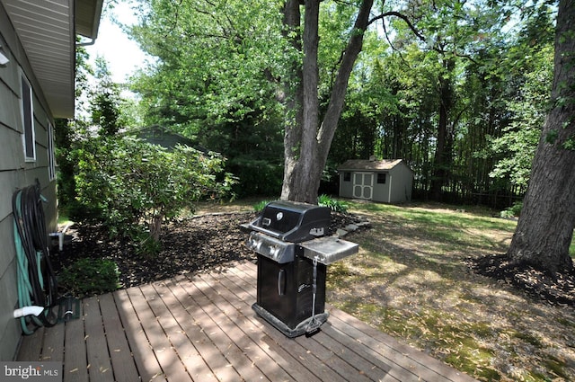 wooden terrace with a storage unit, area for grilling, and an outdoor structure