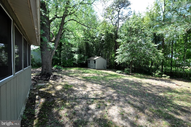 view of yard featuring a storage unit, an outbuilding, and fence