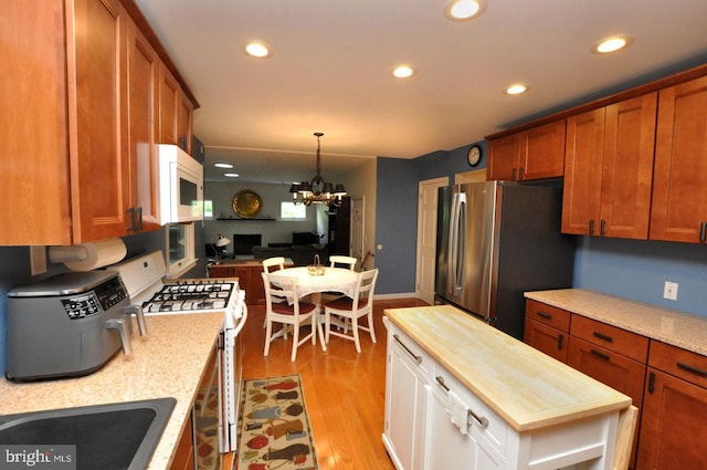kitchen with white appliances, wood counters, recessed lighting, light wood finished floors, and brown cabinetry