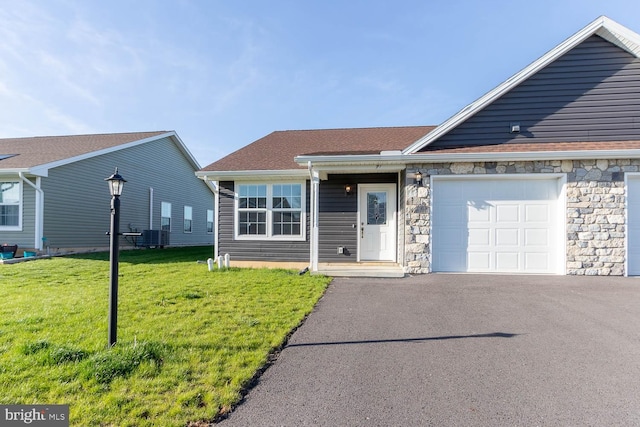 ranch-style house featuring a front yard, driveway, a garage, and stone siding