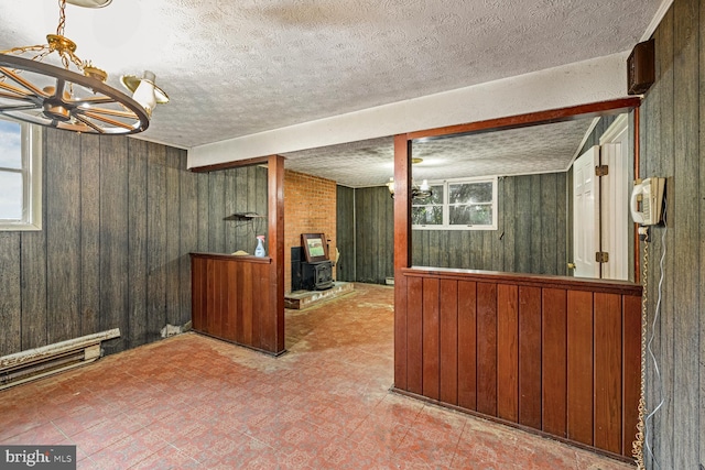 320 Dawn Ave, Woodstock, VA 22664 - bar area with wooden walls, healthy amount of natural light, a wood stove, and a textured ceiling