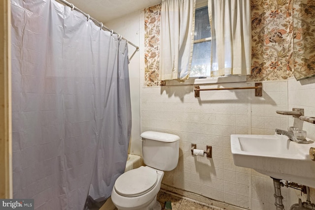 320 Dawn Ave, Woodstock, VA 22664 - bathroom with toilet, tile walls, a sink, wainscoting, and wallpapered walls