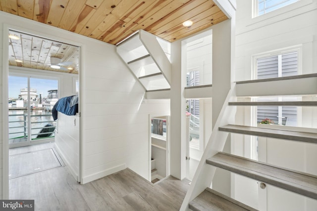 stairway featuring wooden ceiling and wood finished floors