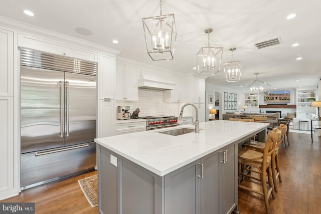 11013 Homeplace Ln, Potomac, MD 20854 - kitchen with high quality appliances, gray cabinetry, a sink, a chandelier, and custom range hood
