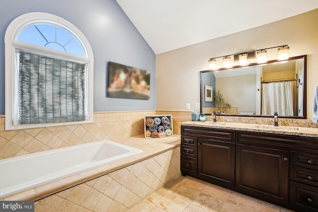 bathroom featuring a bath, double vanity, and high vaulted ceiling