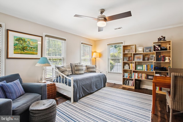 bedroom featuring wood finished floors, baseboards, crown molding, and ceiling fan