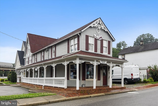 view of front of property with a porch and a shingled roof