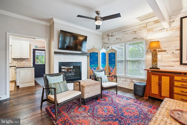 sitting room with a fireplace, crown molding, dark wood-style flooring, a ceiling fan, and wood walls