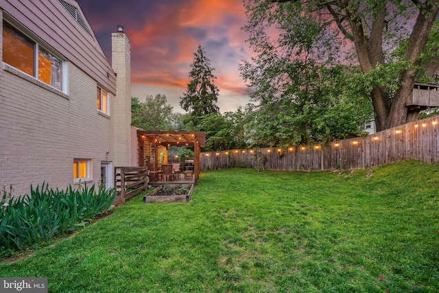 yard at dusk with a vegetable garden and a pergola