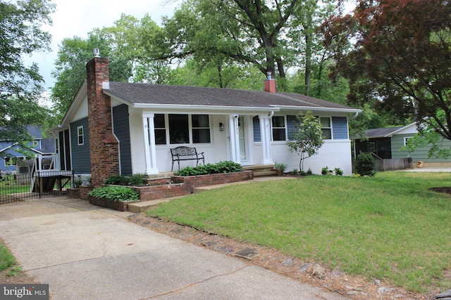 ranch-style home with a chimney, covered porch, and concrete driveway