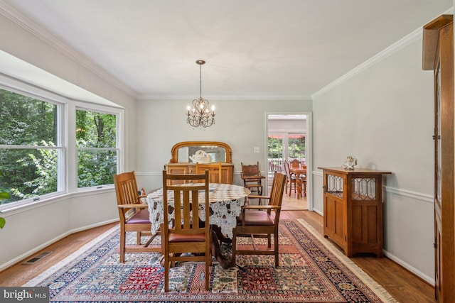 6813 Jeremiah Ct, Fairfax Station, VA 22039 - dining room featuring healthy amount of natural light, light wood finished floors, ornamental molding, and a chandelier