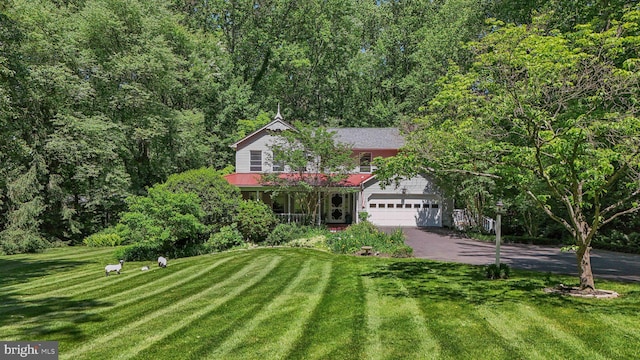 6813 Jeremiah Ct, Fairfax Station, VA 22039 - view of property hidden behind natural elements featuring driveway, a front yard, a garage, covered porch, and a view of trees