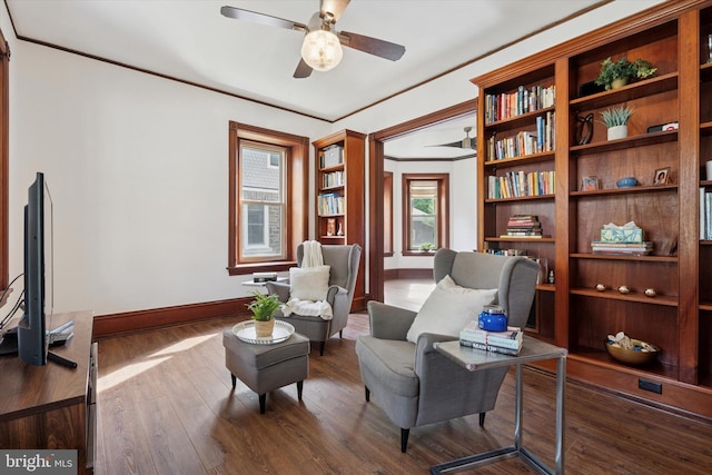 living area featuring baseboards, a ceiling fan, and wood finished floors