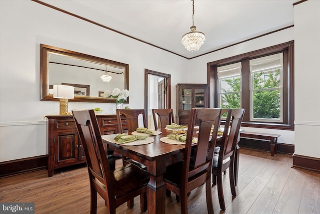 dining room with baseboards, light wood finished floors, and a chandelier