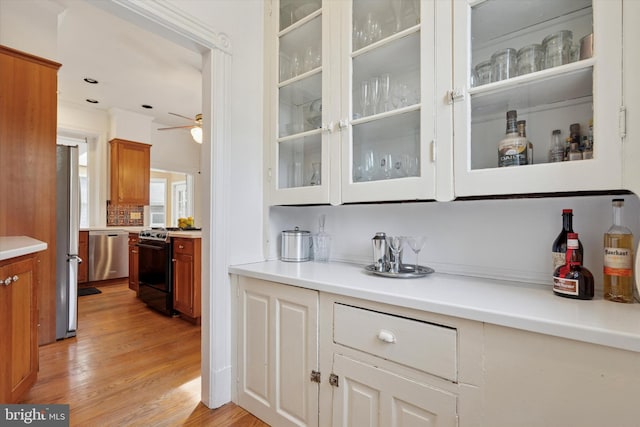 bar with appliances with stainless steel finishes, light wood-type flooring, and a ceiling fan