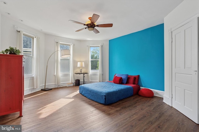 bedroom featuring wood finished floors, ceiling fan, and baseboards