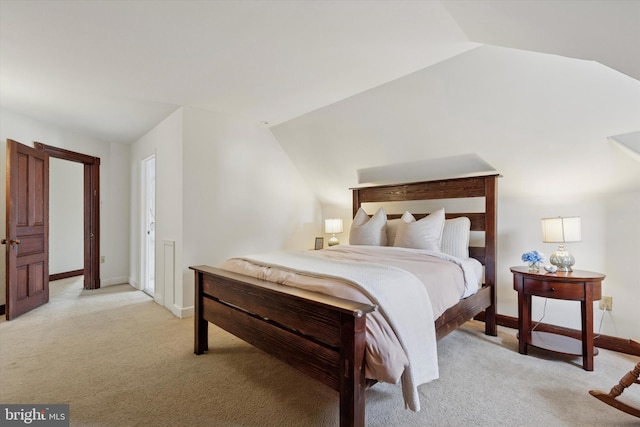 bedroom with light carpet, lofted ceiling, and baseboards