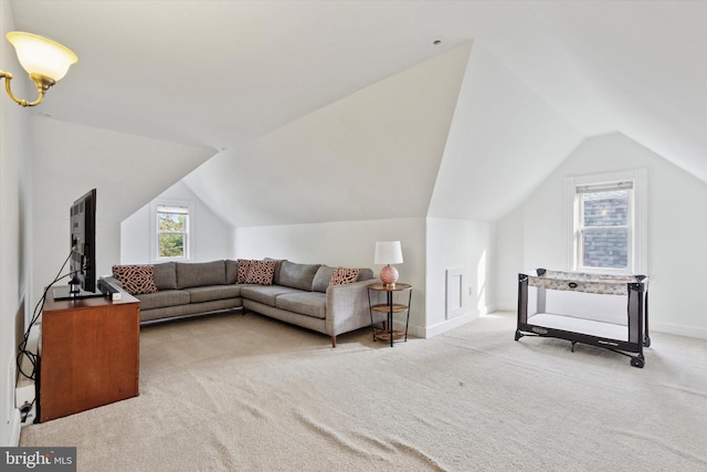 carpeted living room featuring lofted ceiling and baseboards