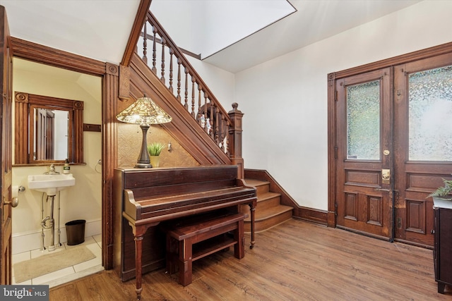 foyer featuring stairway, wood finished floors, and baseboards