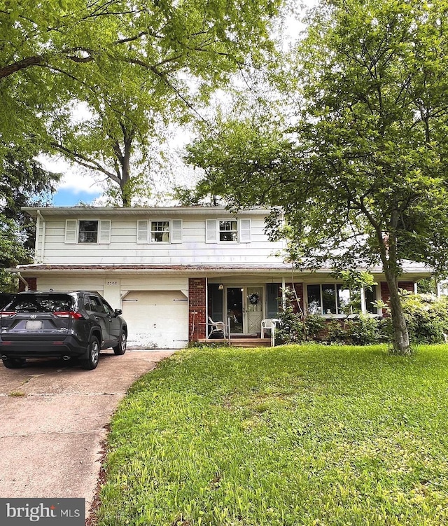 traditional-style house with an attached garage, driveway, and a front yard
