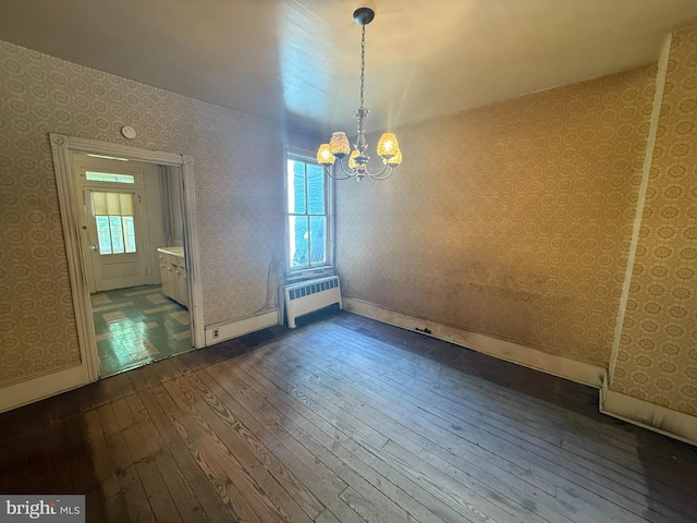 unfurnished dining area featuring dark wood-style flooring, wallpapered walls, plenty of natural light, a chandelier, and baseboards