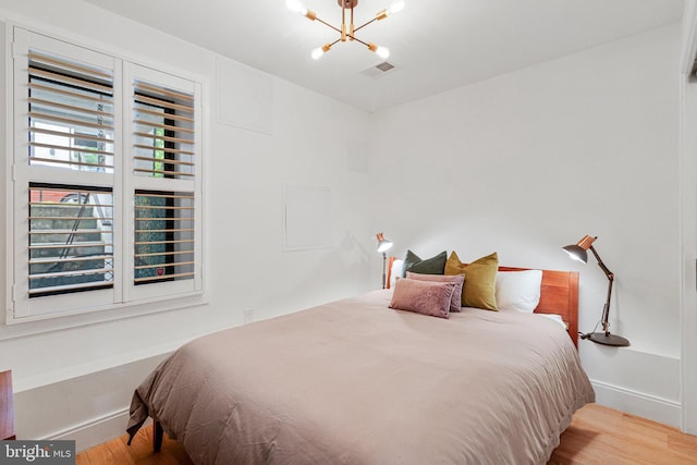1440 Oak St NW Unit 1, Washington, DC 20010 - bedroom with a chandelier, wood finished floors, and baseboards
