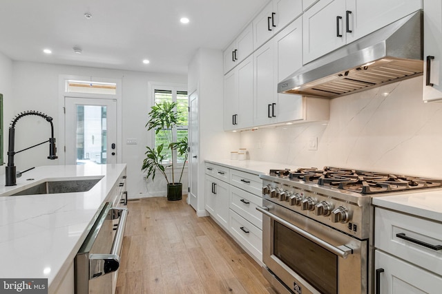 1440 Oak St NW Unit 1, Washington, DC 20010 - kitchen with stainless steel range, under cabinet range hood, a sink, light wood-style floors, and recessed lighting