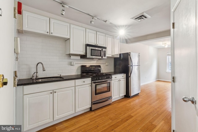 326 S 17th St Unit 3, Philadelphia, PA 19103 - kitchen featuring stainless steel appliances, a sink, dark countertops, and white cabinets