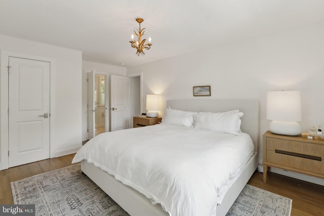 bedroom featuring wood finished floors and a chandelier