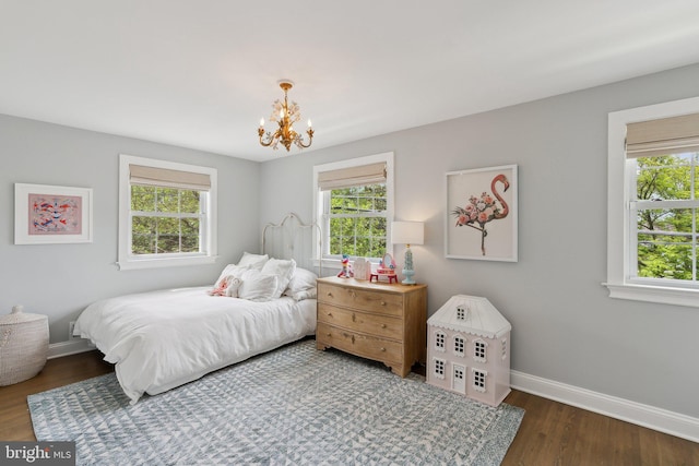 bedroom featuring a chandelier, baseboards, and wood finished floors