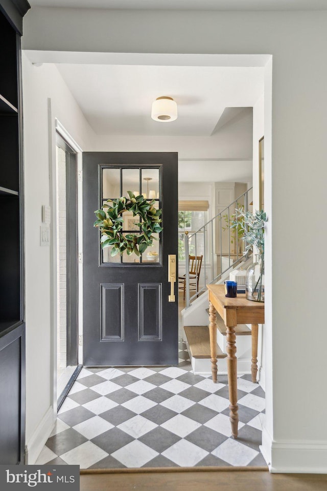 foyer entrance featuring tile patterned floors, stairs, and baseboards