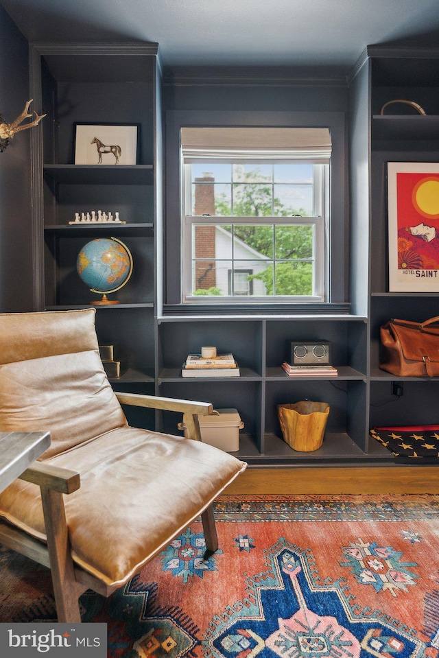 sitting room featuring crown molding and wood finished floors