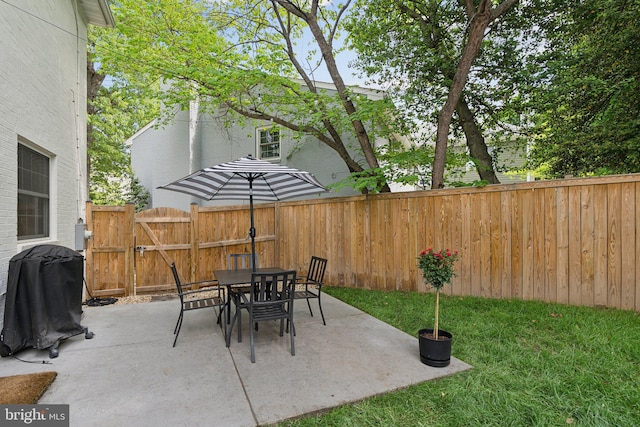 view of patio with fence, outdoor dining area, and a gate