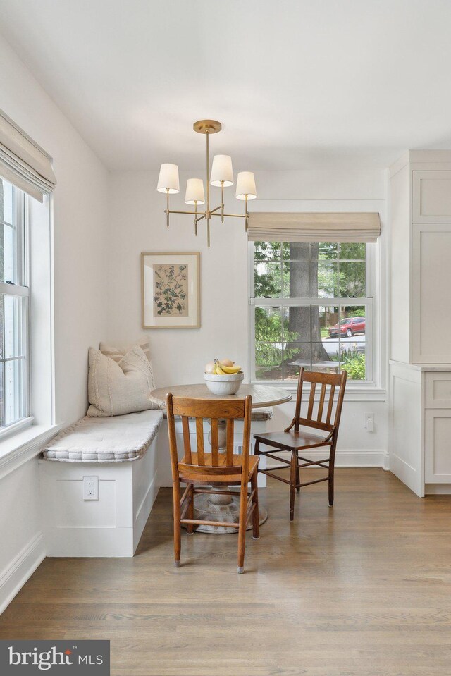 dining area featuring a chandelier, light wood finished floors, and baseboards