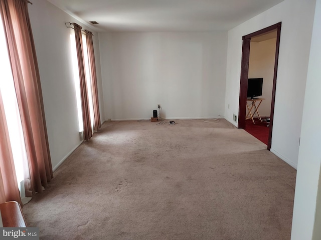 carpeted empty room with baseboards