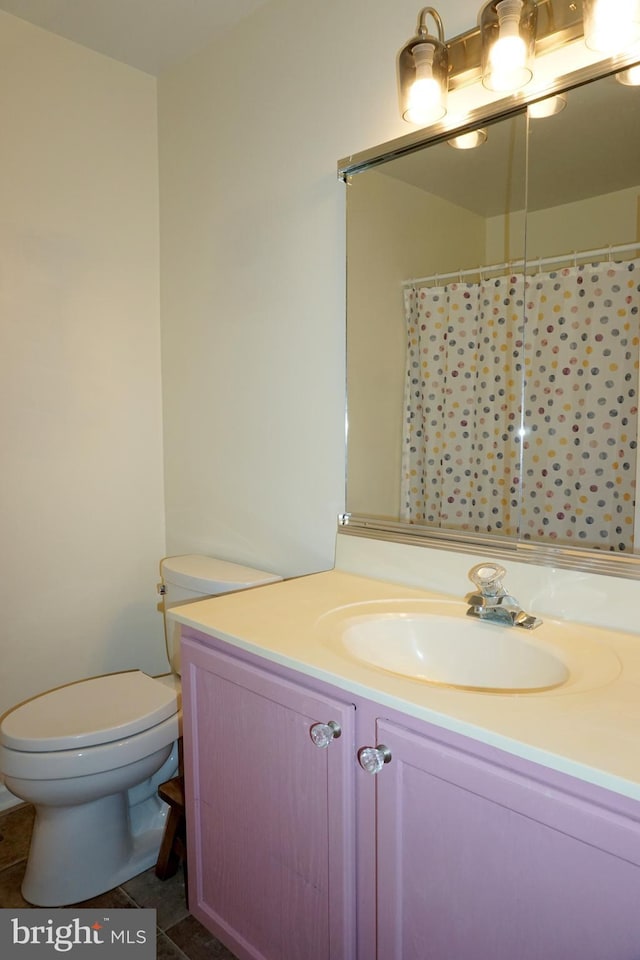 full bathroom with toilet, vanity, and tile patterned floors
